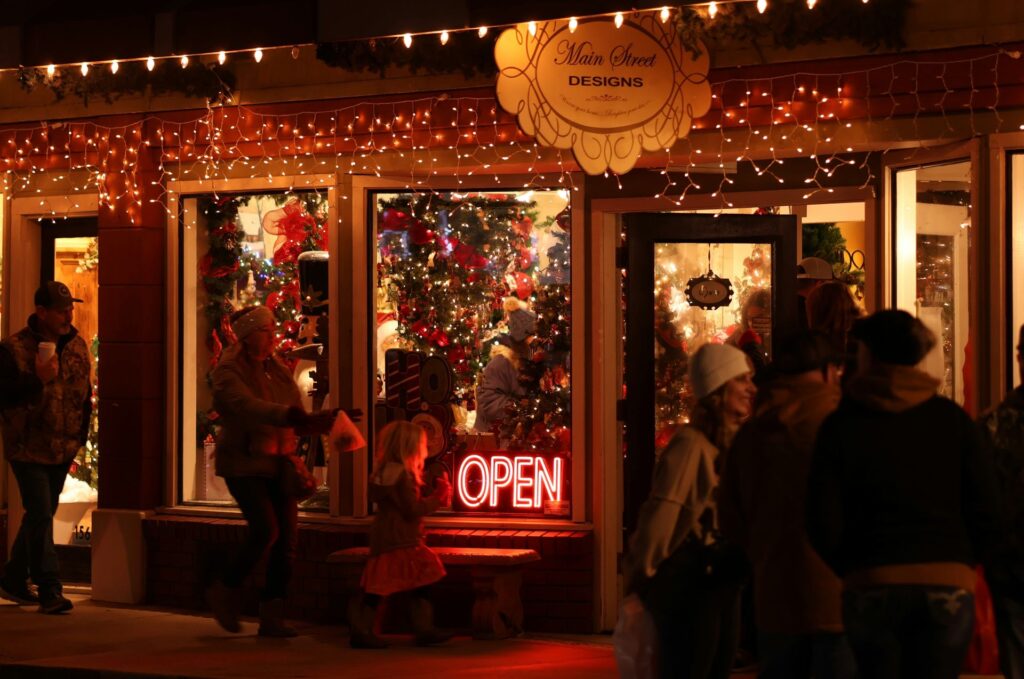 Peaceful holiday shop window with festive lights and greenery, representing mindfulness, financial wellness, and emotional balance during the holidays.